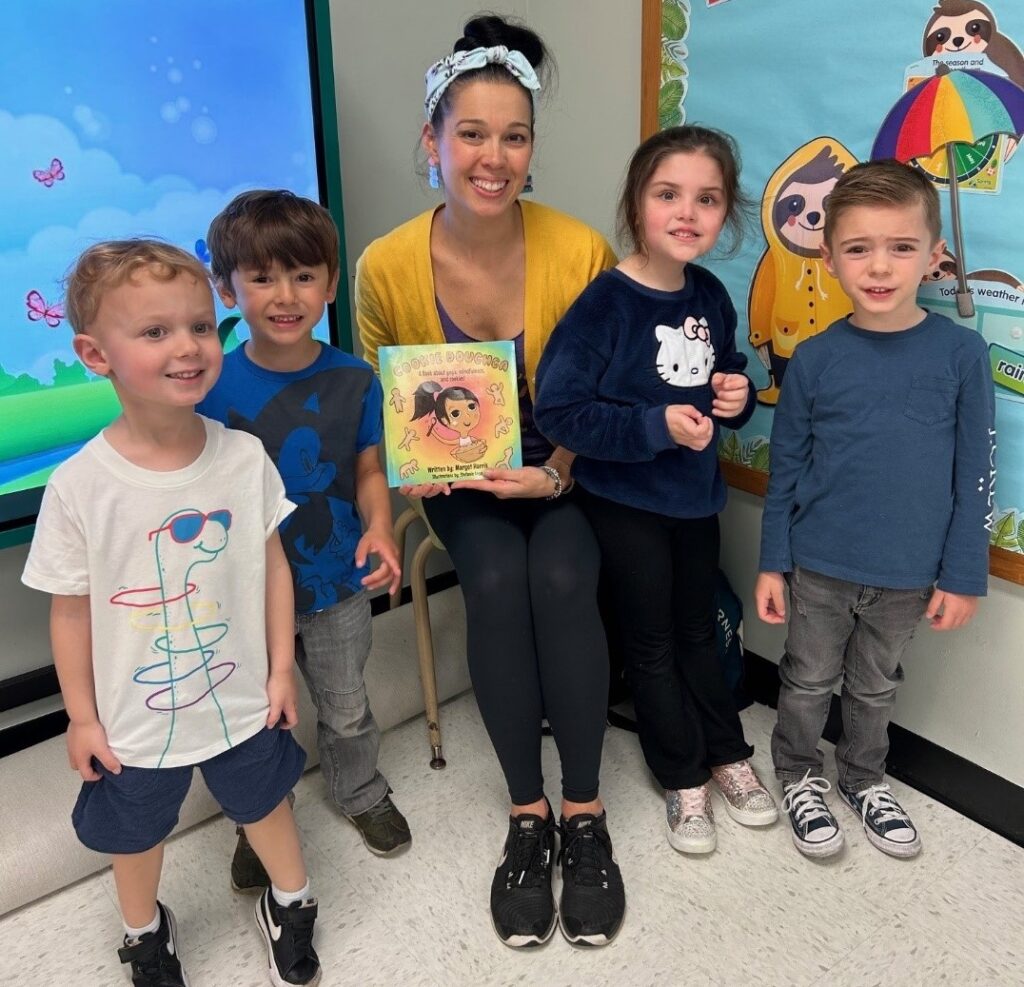 "Cookie Doughga" author Margot Harris poses with her book and BCCS students