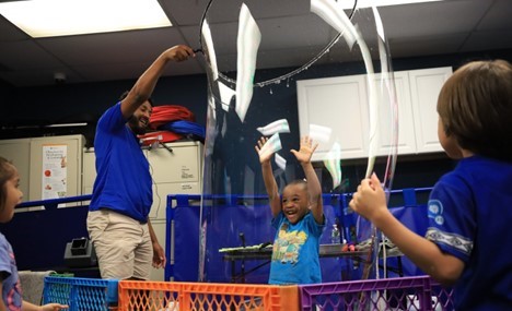 A BCCS student enjoys being insidle a giant bubble during the bubble show.