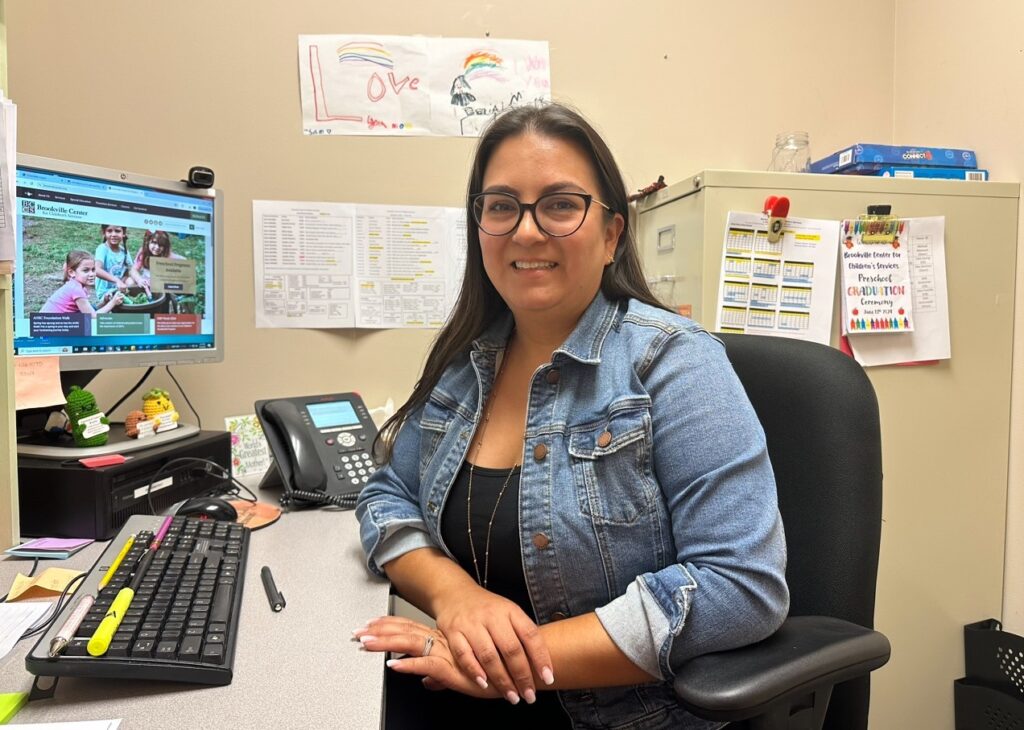 Vanessa Martinez-Mautino poses for a photo at her desk
