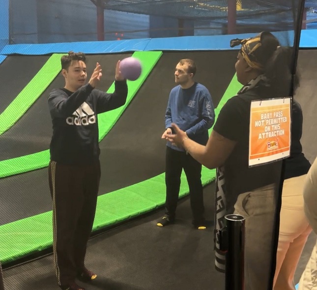 A resident of the CRP throws a ball to a staff member at Bounce! Family Entertainment Center.