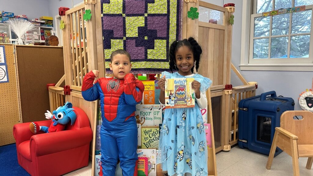 Two Post Avenue students, one dressed as Spiderman and the other wearing a Bluey dress for Reading Across America week