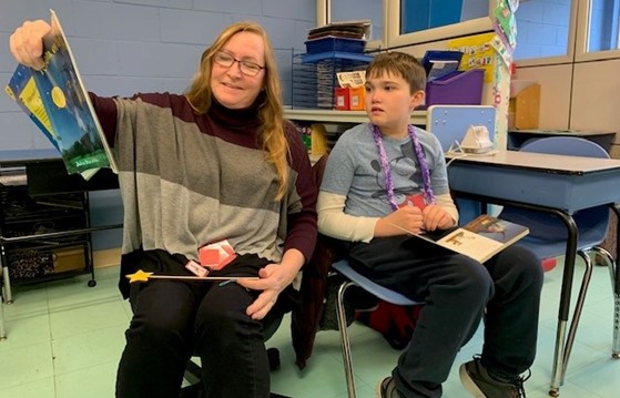 A child supported by the BCCS Home & Community Program reads with a teacher.