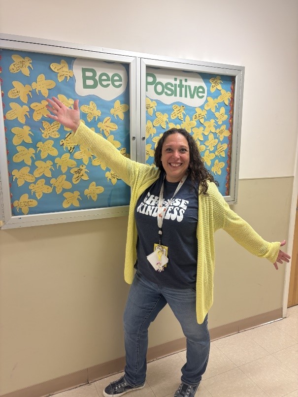 Marcus Avenue Preschool Social Worker Lisa Kaplan in front of her "Bee Positive" board