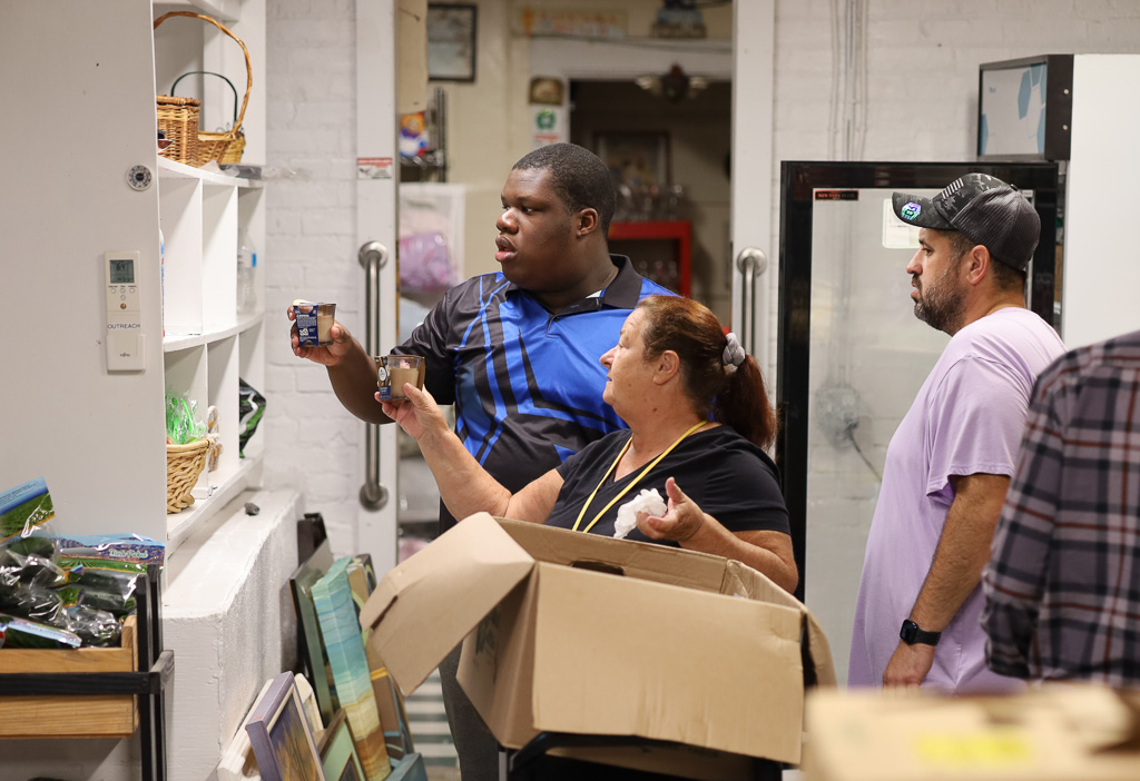 Transition Program student Judley Toussaint places items on a shelf.