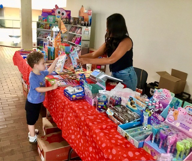 A Marcus Avenue parent helps a student pick out a book at the book fair.