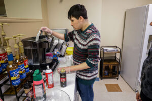 A BCCS Student works at coffee machine at Brookville Beans