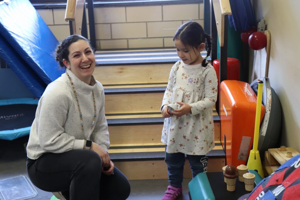 A BCCS Teacher smiles while helping a student