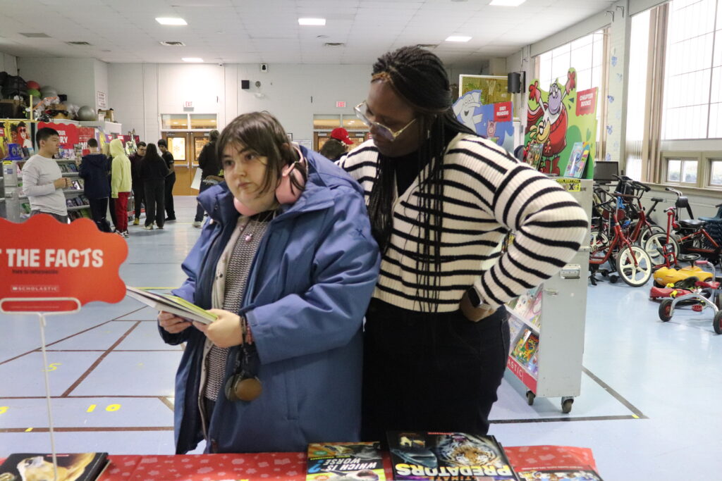 A BCCS staff member helps a student shop for books at the book fiar.