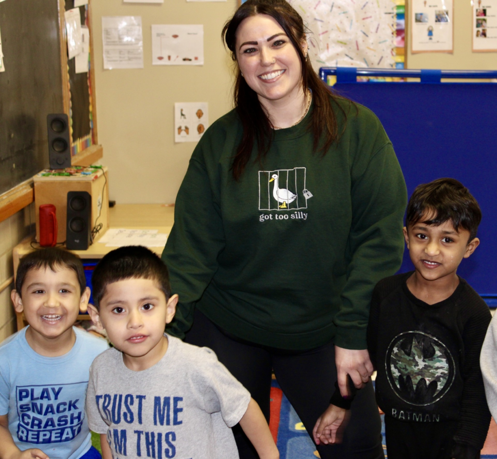 A Round Hill Road Preschool teacher with three students.