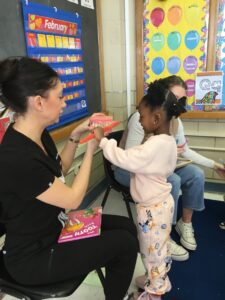 A Round Hill Road student practices brushing teeth with the help of dental assistant Megan Ryan.