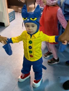 Preschooler dressed as a Halloween cat arrives at the party