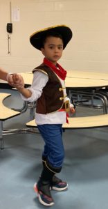 A preschooler dressed as a cowboy arrives