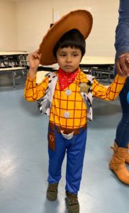 A preschooler dressed as a cowboy arrives