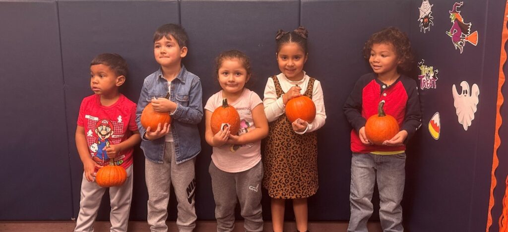 Students at Marcus Avenue School pose with pumpkins