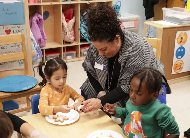 Assemblywoman Gina Sillitti decorates a holiday cookie with BCCS students