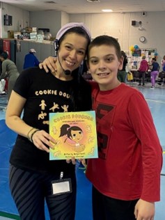 Another student and teacher pose with a book during Reading Across America Week