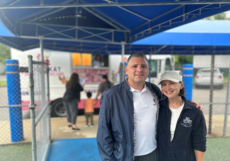 Rocco and Samantha Bove pose for a photo in front of the ice cream truck they sponsored.