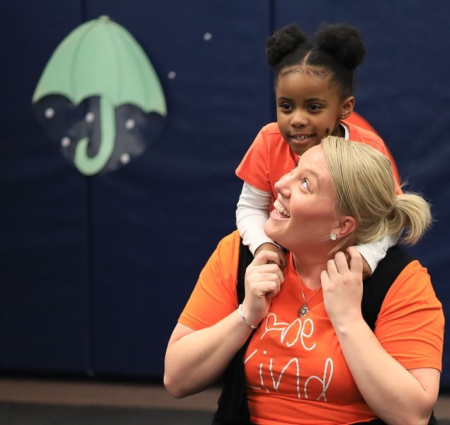 A Brookville Center for Children’s Services teacher carries a student on her back on the first day of school