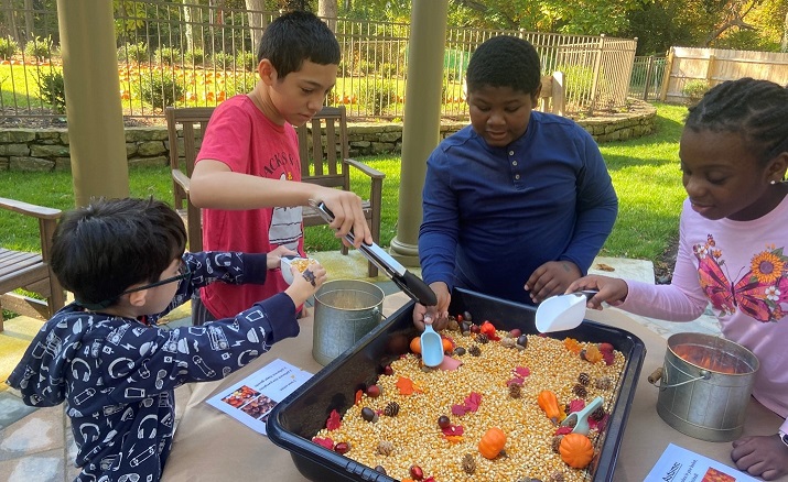 Four Children's Education Center students play with the fall-themed sensory bins.