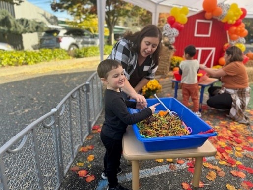 A Barbara C. Wilson Preschool student enjoys a sensory table at he Fall Festival.