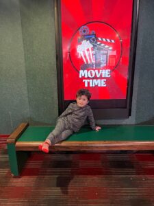 A Barbara C. Wilson student in front of a sign that says "Movie Time"