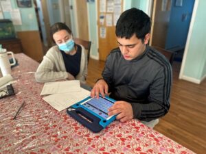 A resident at the Children's Residential Center used his iPad to communicate with a staff member.