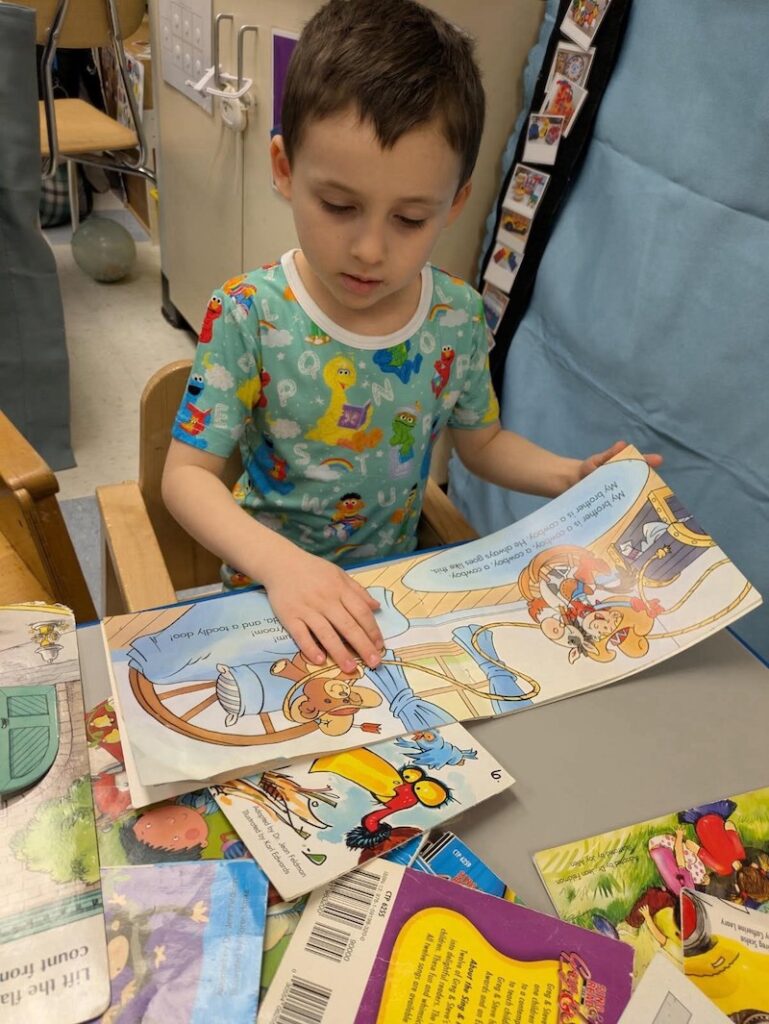 Another student reads a book in his pajamas for Read Across America