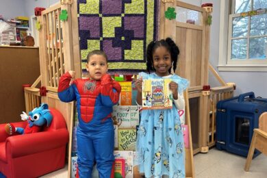 Two Post Avenue students, one dressed as Spiderman and the other wearing a Bluey dress for Reading Across America week