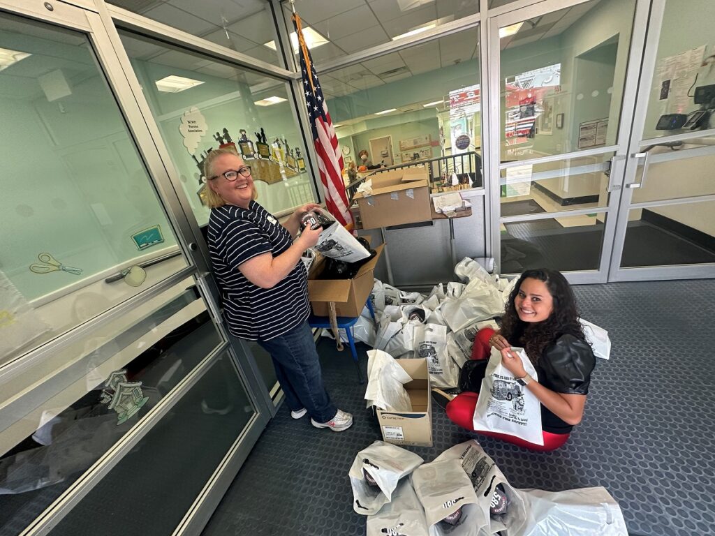 Two Parents’ Association members pack gift bags for students at an event