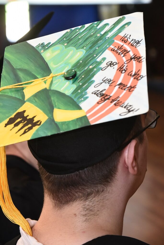 A decorated graduation cap reading "It's not where you go. It's who you meet along the way!"
