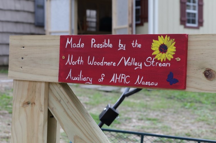 A red handpainted sign reads "Made Possible by the North Woodmere/Valley Stream Auxiliary of AHRC Nassau"