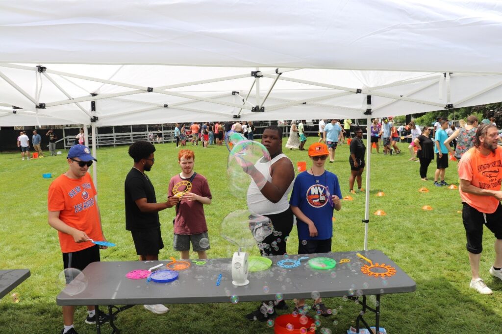 Education Center students blow bubbles at a table.