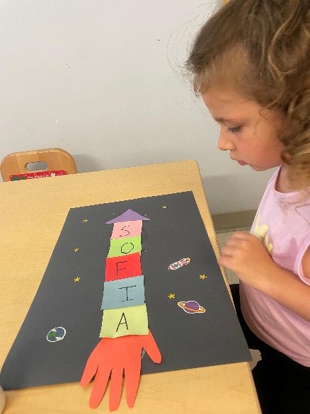 A summer session student works on a space-themed arts and crafts project.
