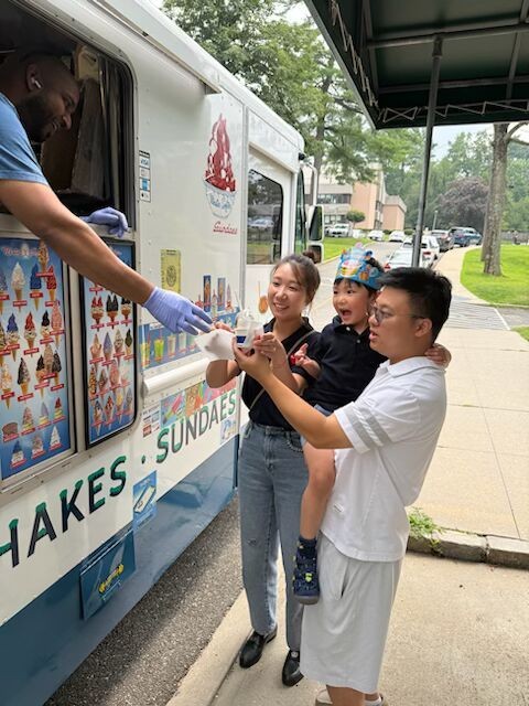 Theo Xiong’s parents help him order ice cream at the truck they sponsored.