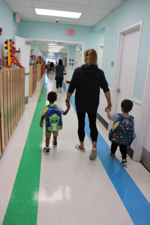 A BCCS teacher holds the hands of two students on the first day of school.