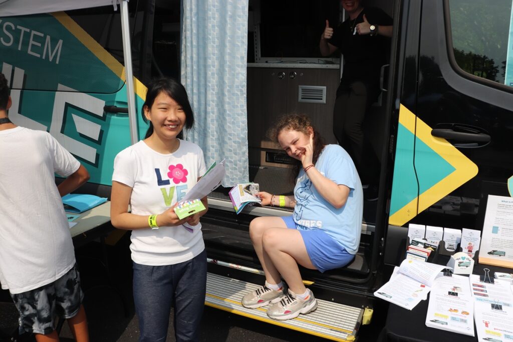 Two young women supported by the Children's Residential Program enjoy the touch-a-truck event.