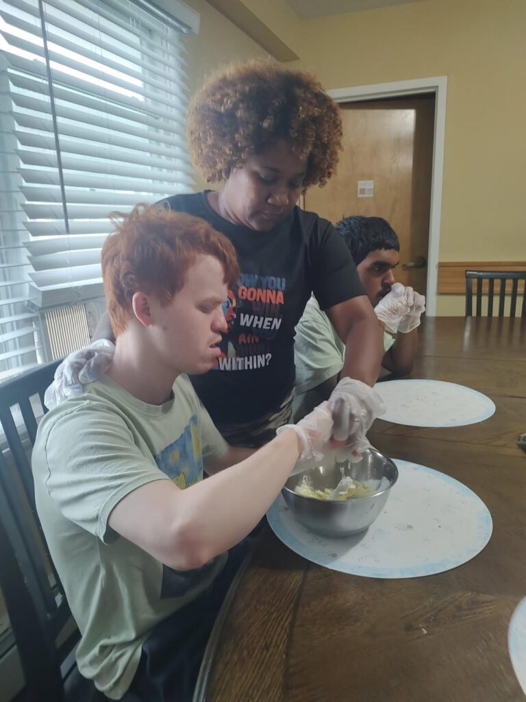 Direct Support Professional Najoya Stewart-Leslie helps a CRP resident with his task.