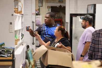 Transition Program student Judley Toussaint places items on a shelf.