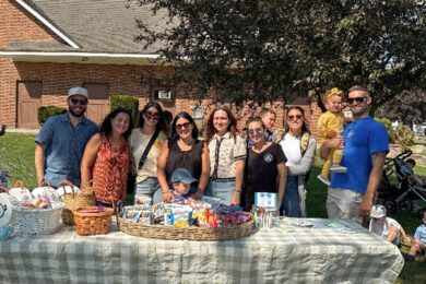 The Barbara C. Wilson Preschool Fathers’ Group pose behind a picnic table.