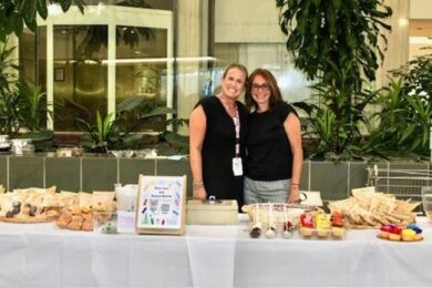 Two Marcus Ave. teachers behind a table of snacks at Back-to-School Night