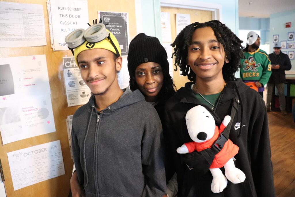 Three Children's Residential Program reisdents and staff wear costumes on Halloween.