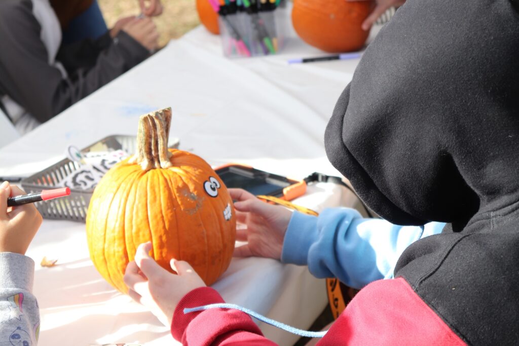 A Children's Education Center student decorates a pumpkin at the Fall Festival