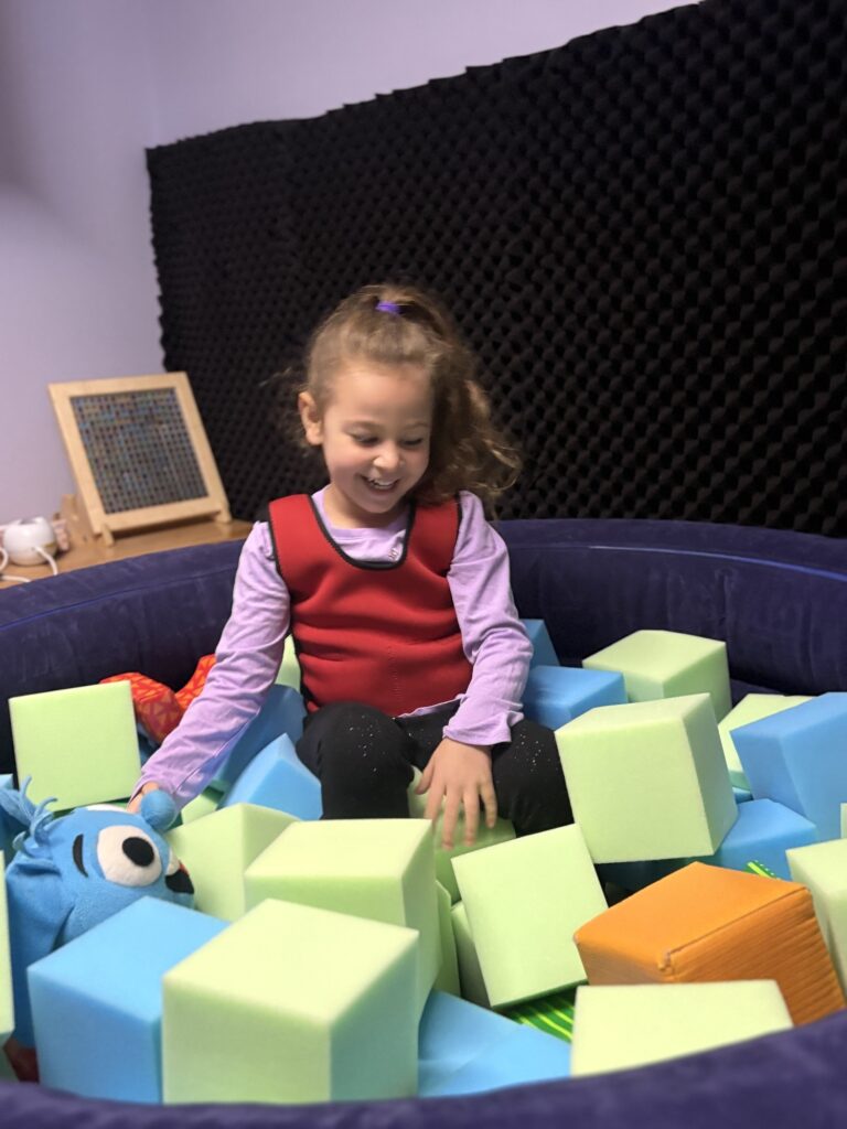 A BCCS student plays with foam blocks in the sensory room.