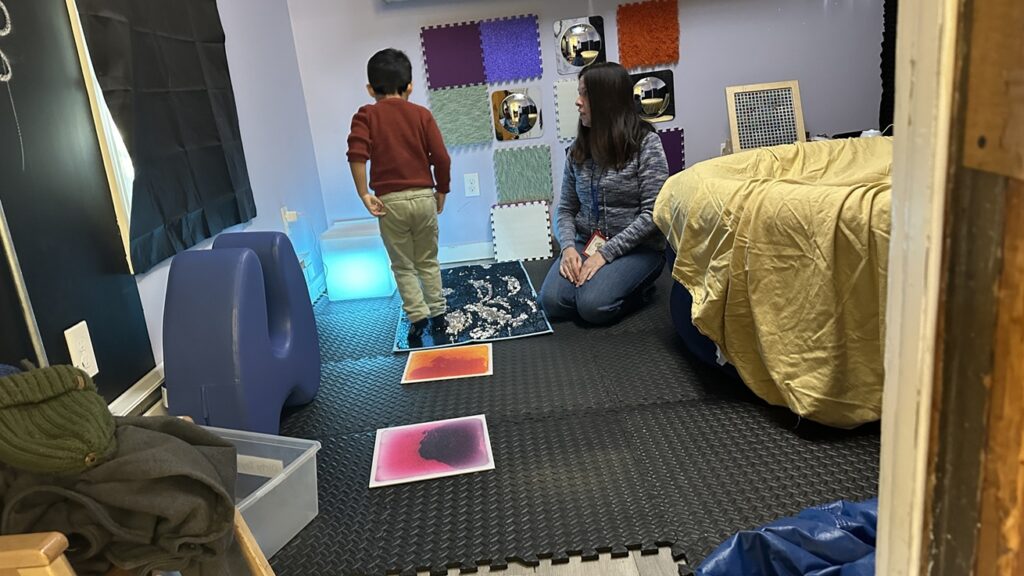 A student and staff member in the sensory room.