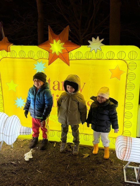Three BCW students in front of a light up sign at the Luminocity light display.